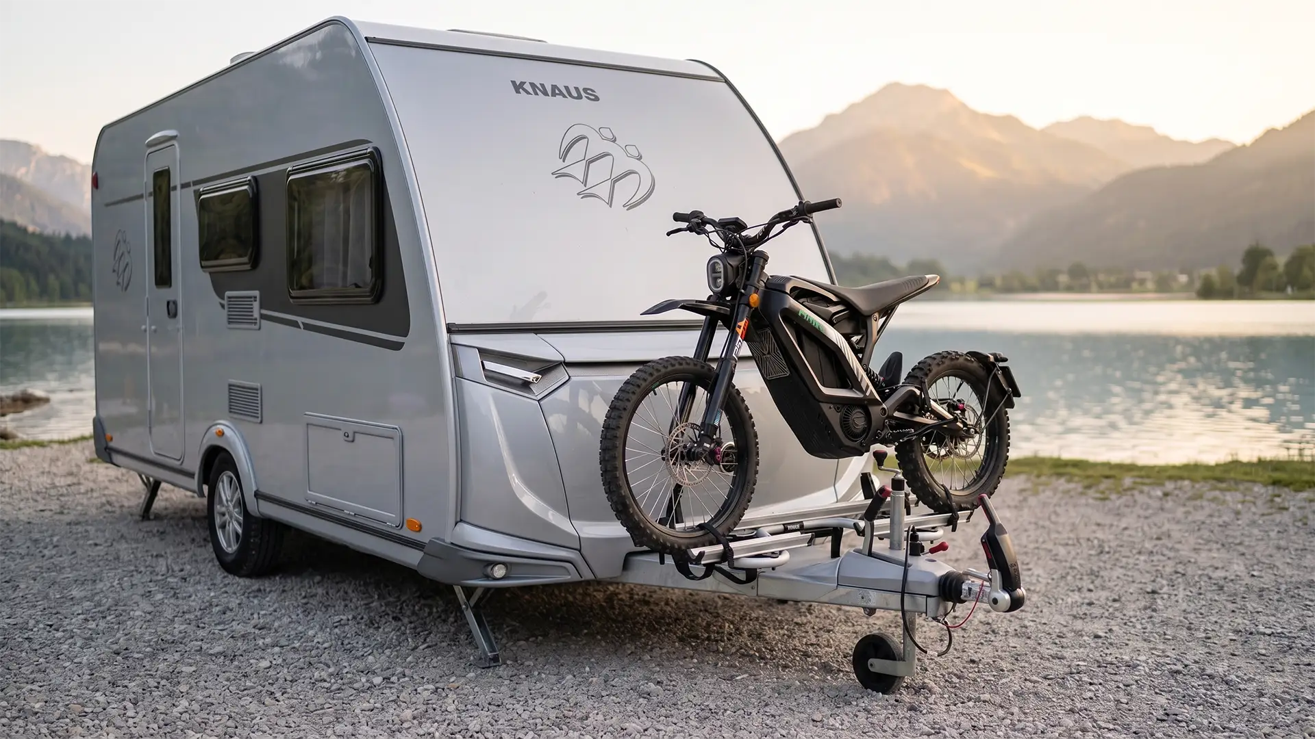HMW FoxE auf einem Campinganhäger befestigt, der bei Sonnenuntergang an einem Alpensee steht